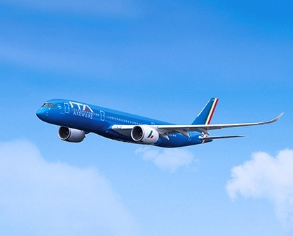 a blue airplane flying in the sky