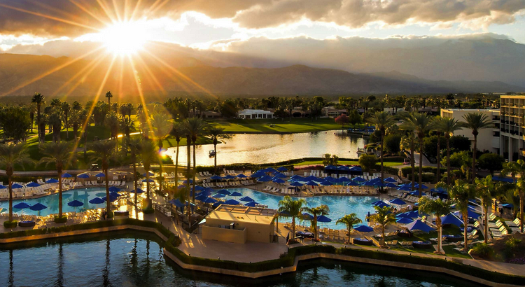 a pool with chairs and umbrellas in a resort