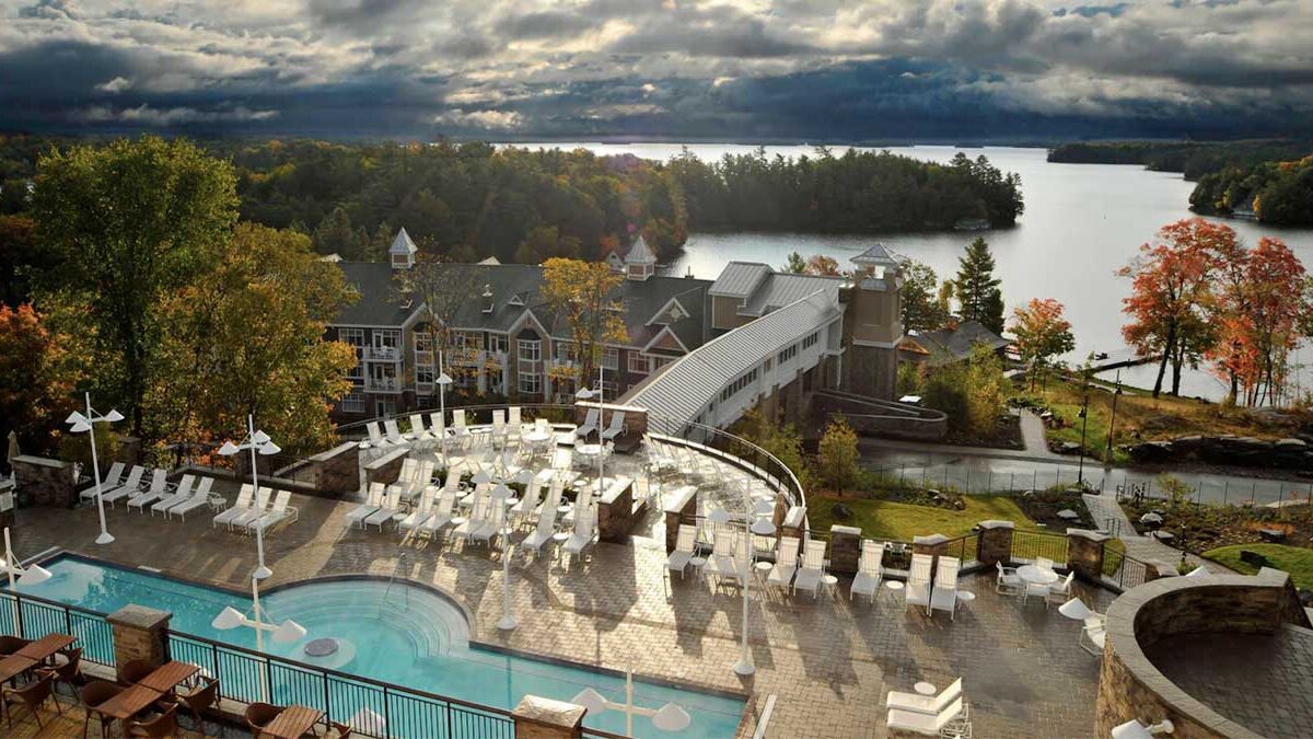 a pool and chairs by a building